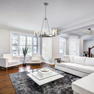 5 Light wagon wheel Worthington chandelier in a modern white living room, hanging above a glass coffee table.