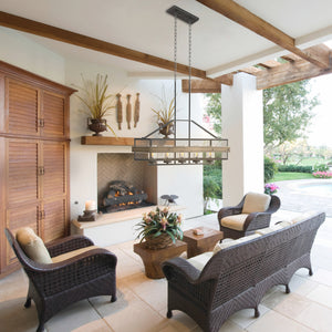 Barnwood linear outdoor chandelier in the backyard covered outdoor living area, hung above a coffe table and seating area..