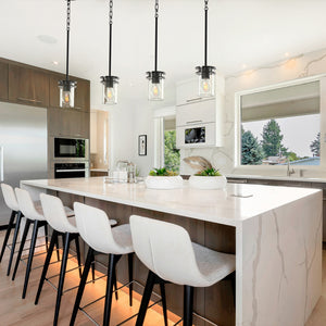 4 Devonshire cylinder pendant lights in matte black above kitchen island.