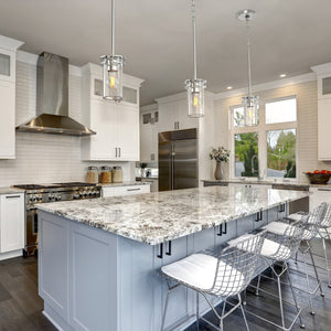 3 Devonshire cylinder pendant lights in brushed nickel above a kitchen island.