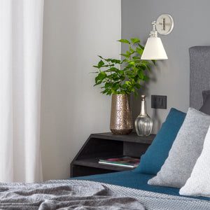 Moti armed sconce with etched glass in antique polished nickel on the wall in bedroom by the bed, above a night table.